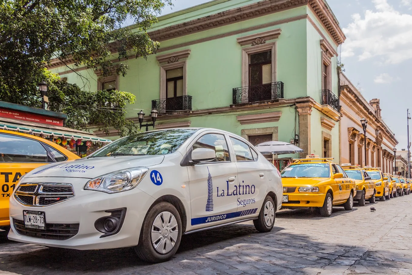 Unidad de servicio de La Latino Seguros estacionada en el Centro Histórico de Oaxaca